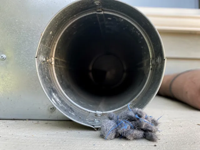 Dartmouth Dryer Vent Cleaning technician using specialized equipment to clear severe dryer vent blockage in Dartmouth